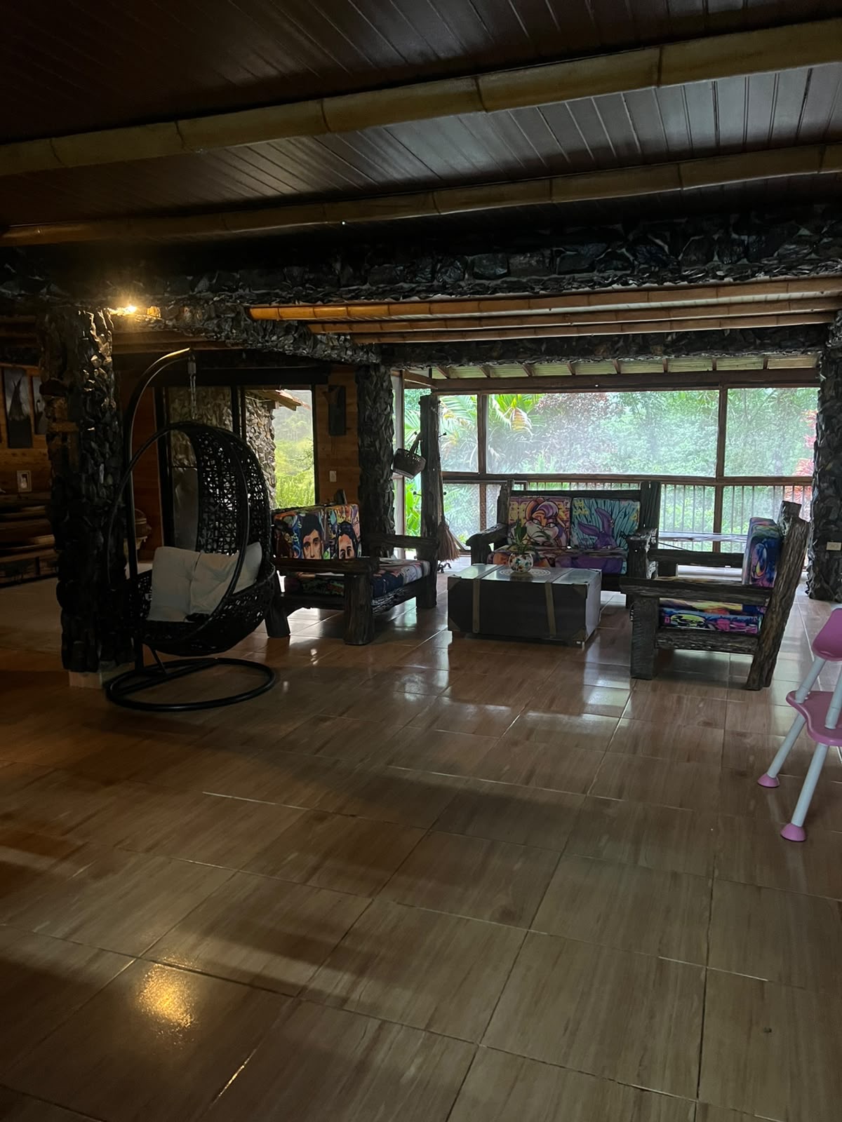 The living room — hanging chair, hand-painted cushions